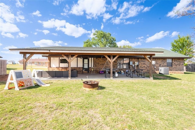 back of house featuring a patio, brick siding, fence, and a yard