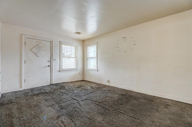 empty room with baseboards, visible vents, and carpet floors