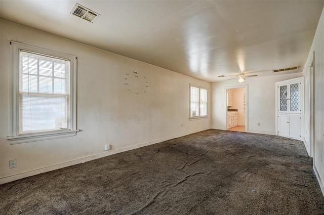 spare room with visible vents, ceiling fan, and carpet flooring