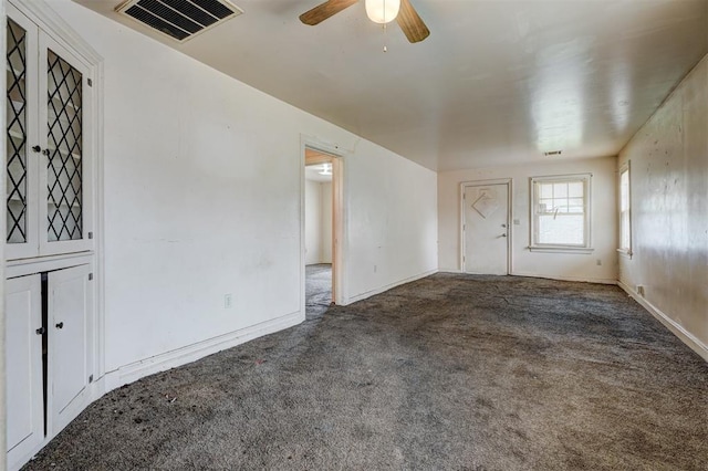 spare room featuring baseboards, carpet flooring, ceiling fan, and visible vents