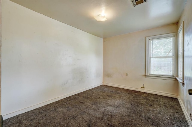 spare room with visible vents, a wealth of natural light, carpet floors, and baseboards