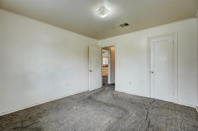 unfurnished bedroom featuring visible vents, crown molding, and carpet flooring