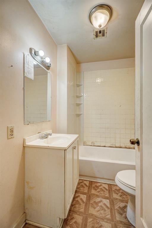 bathroom featuring vanity, toilet, visible vents, and shower / bath combination