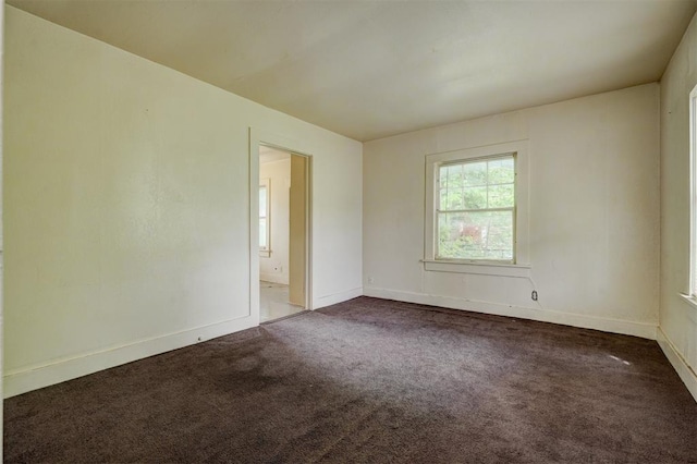 spare room featuring baseboards and carpet flooring