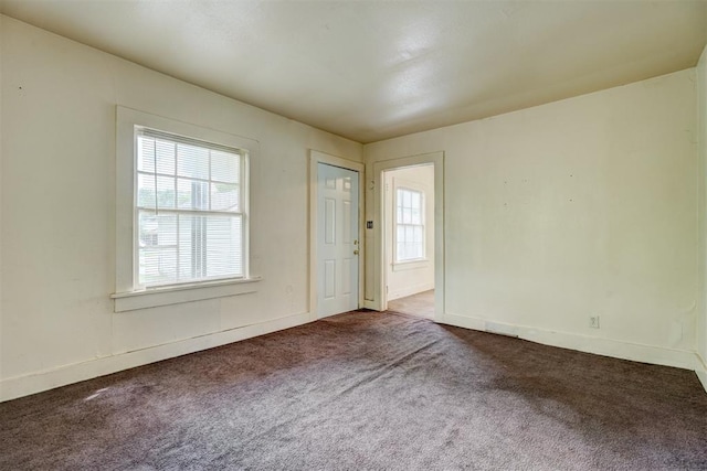 unfurnished room featuring carpet flooring and baseboards