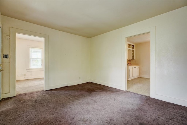 unfurnished room featuring carpet floors and baseboards