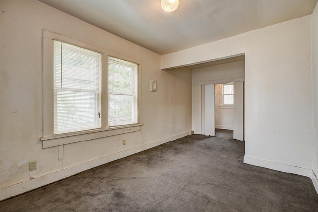 carpeted empty room featuring baseboards