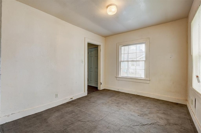 unfurnished bedroom featuring baseboards, multiple windows, and carpet
