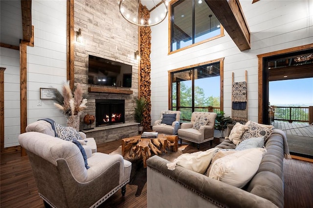 1329 Lake Ridge Ln, Broken Bow, OK 74728 - living area featuring beamed ceiling, wood walls, an outdoor stone fireplace, wood finished floors, and a high ceiling