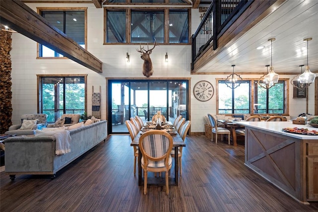1329 Lake Ridge Ln, Broken Bow, OK 74728 - dining room with a chandelier, dark wood-type flooring, a towering ceiling, and wooden walls