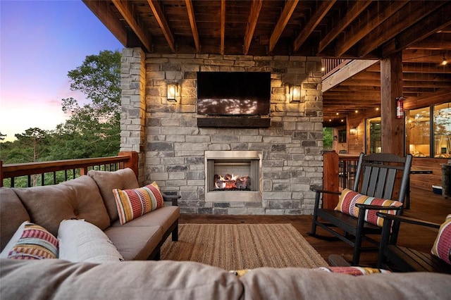 1329 Lake Ridge Ln, Broken Bow, OK 74728 - living area featuring wood finished floors and an outdoor stone fireplace
