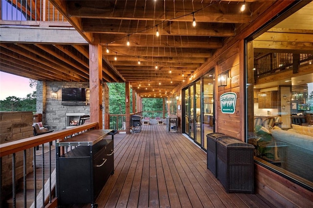 1329 Lake Ridge Ln, Broken Bow, OK 74728 - deck at dusk with an outdoor stone fireplace