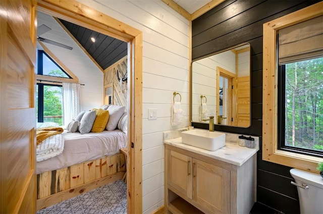 1329 Lake Ridge Ln, Broken Bow, OK 74728 - ensuite bathroom featuring wood walls, toilet, vanity, and lofted ceiling