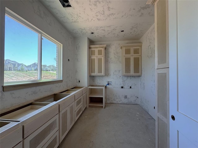 kitchen with glass insert cabinets and concrete flooring