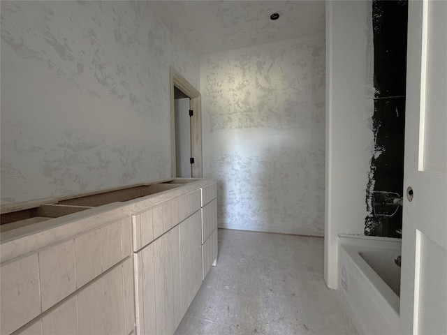 bathroom with a tub to relax in and unfinished concrete floors