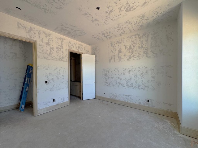 unfurnished bedroom featuring baseboards and concrete flooring