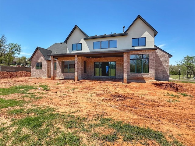 back of house with stucco siding and brick siding