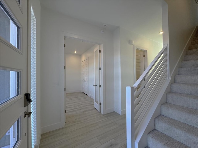 stairway with recessed lighting, baseboards, and wood finished floors