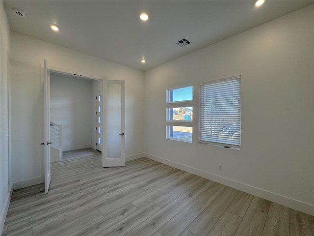 spare room featuring visible vents, recessed lighting, baseboards, and light wood-style floors