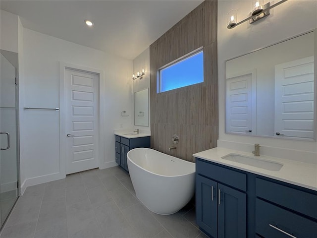 full bath featuring a sink, tile patterned flooring, a freestanding tub, two vanities, and a stall shower