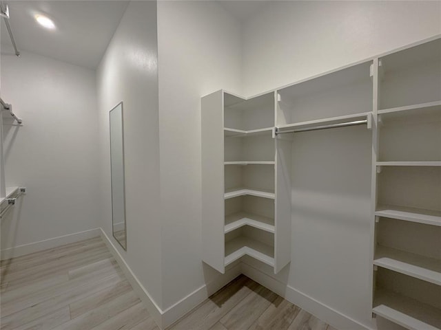 walk in closet with wood finished floors