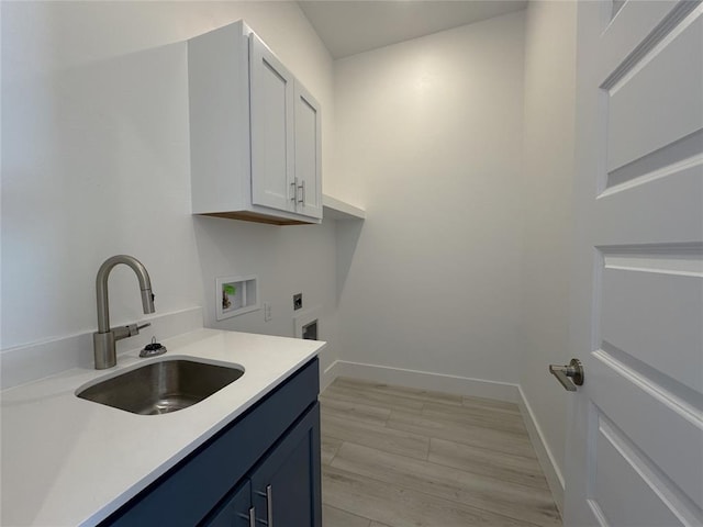 clothes washing area with washer hookup, electric dryer hookup, cabinet space, a sink, and baseboards