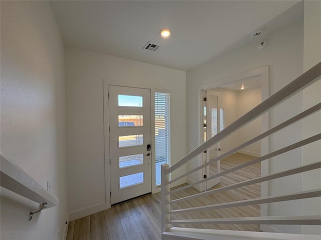 foyer featuring stairway, recessed lighting, baseboards, visible vents, and hardwood / wood-style flooring