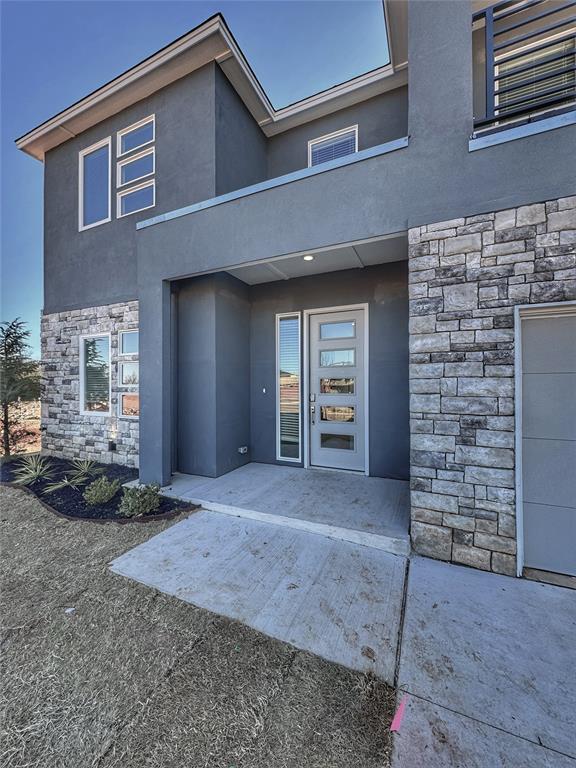 view of exterior entry with stucco siding and stone siding