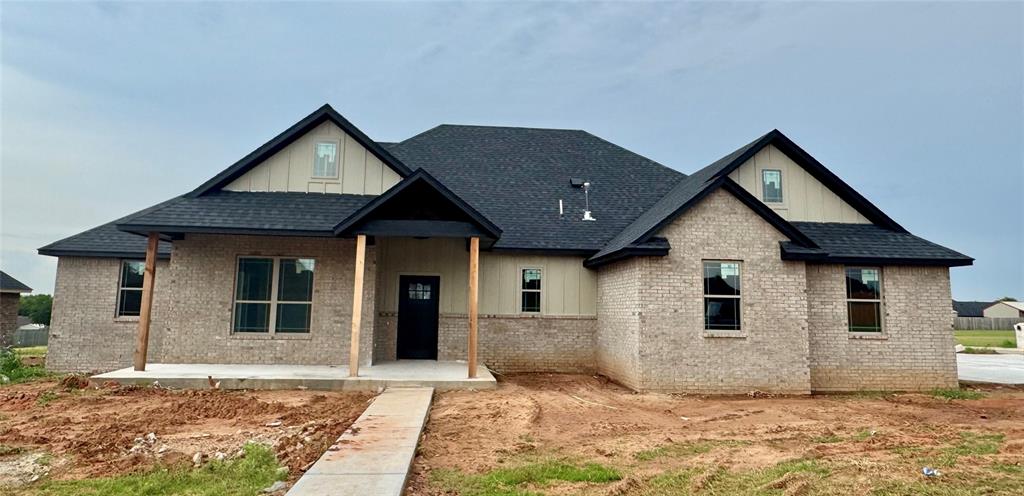 4129 Sambar St, Tuttle, OK 73089 - view of front of home with board and batten siding, roof with shingles, and brick siding