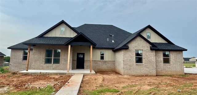 4129 Sambar St, Tuttle, OK 73089 - view of front of home with board and batten siding, roof with shingles, and brick siding