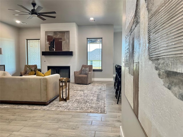 4129 Sambar St, Tuttle, OK 73089 - living area with a large fireplace, wood finished floors, and a ceiling fan