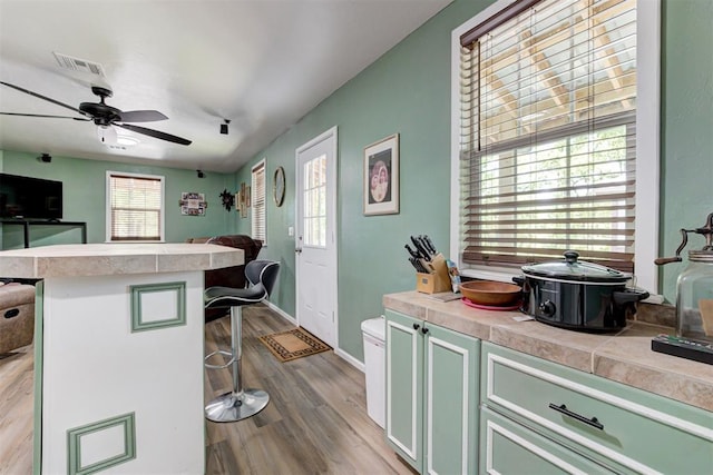 kitchen featuring a breakfast bar, visible vents, open floor plan, and light countertops