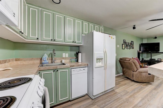 kitchen with a sink, light wood-type flooring, white appliances, green cabinetry, and open floor plan