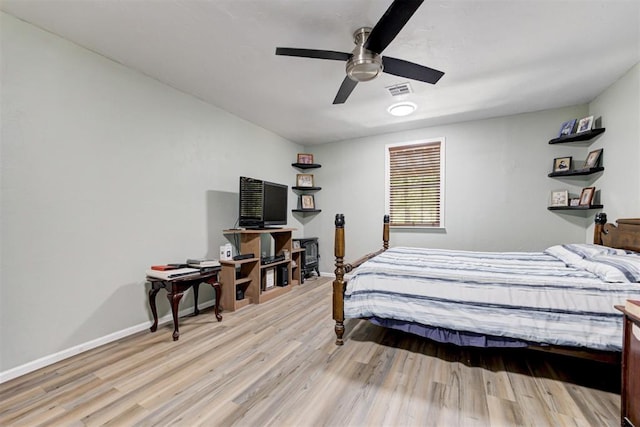 bedroom with baseboards, visible vents, ceiling fan, and light wood finished floors
