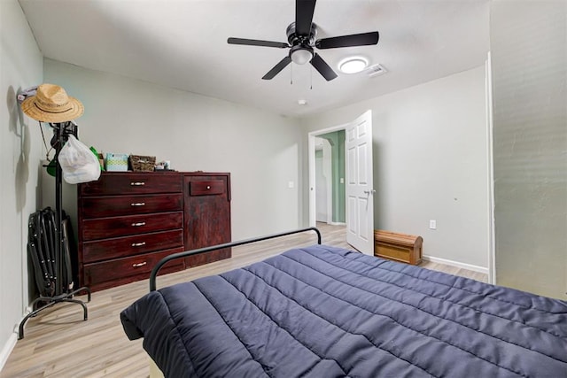 bedroom featuring light wood-style floors, ceiling fan, visible vents, and baseboards