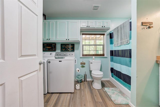 full bath featuring independent washer and dryer, a shower with curtain, visible vents, toilet, and wood finished floors
