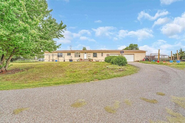 ranch-style house featuring an attached garage, driveway, and a front yard