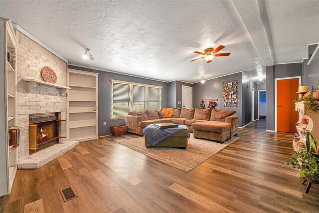 living area featuring a textured ceiling, visible vents, and wood finished floors