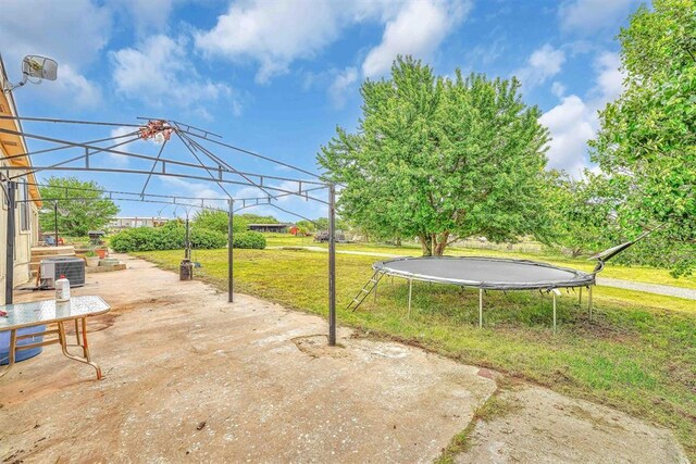 view of yard featuring a patio, a gazebo, central AC unit, and a trampoline