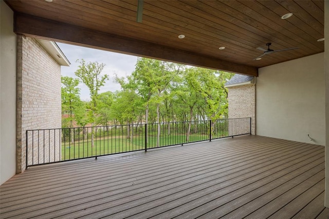 wooden deck featuring fence, a ceiling fan, and a lawn