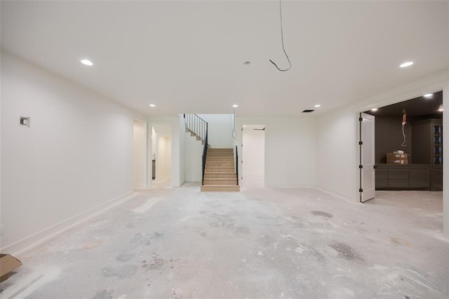 finished basement featuring stairway, recessed lighting, and baseboards