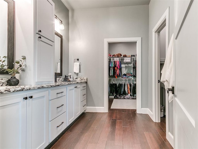 3537 W Fox Ln, Newcastle, OK 73065 - bathroom featuring wood finished floors, vanity, baseboards, and a walk in closet