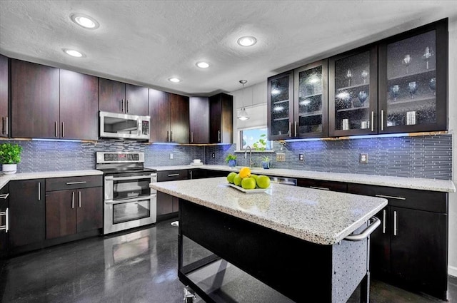 kitchen with a breakfast bar, recessed lighting, a textured ceiling, a sink, and stainless steel appliances