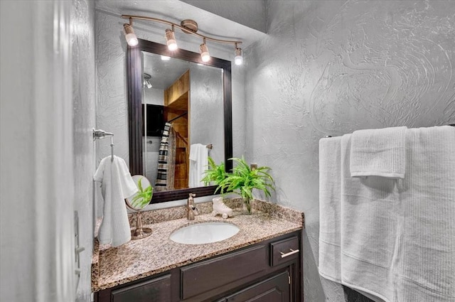 bathroom with vanity and a textured wall