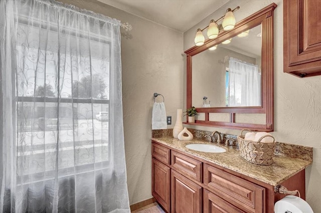 bathroom featuring a textured wall and vanity