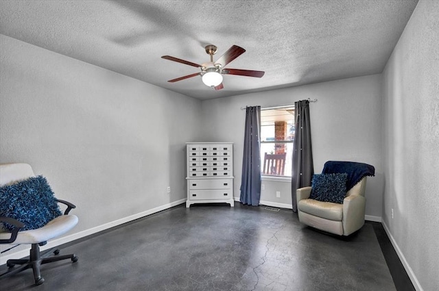 sitting room featuring baseboards, ceiling fan, concrete floors, and a textured ceiling