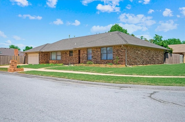 ranch-style house featuring a garage, fence, driveway, and a front yard