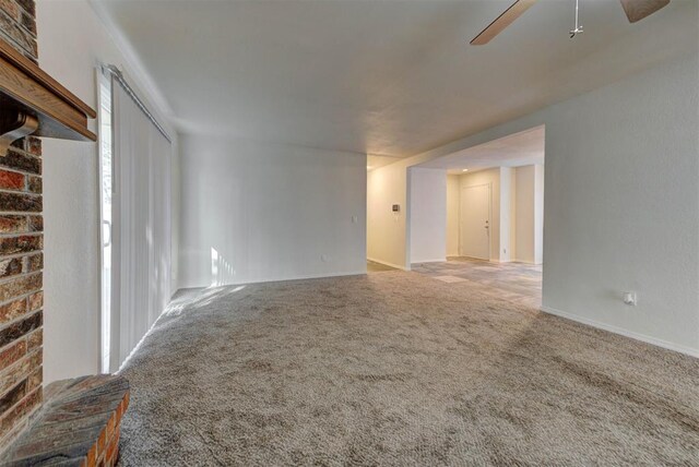 unfurnished living room featuring baseboards, ceiling fan, and carpet
