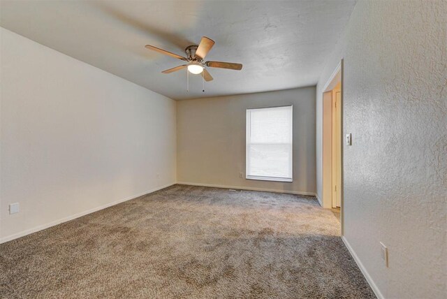 unfurnished room with baseboards, ceiling fan, and carpet