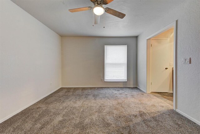 carpeted empty room with baseboards and ceiling fan
